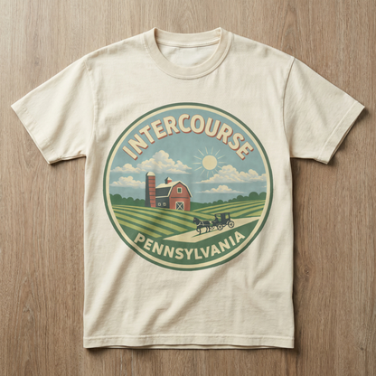 Beige t-shirt with Intercourse, Pennsylvania graphic on a wooden surface